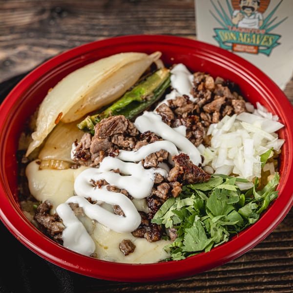 A red bowl of Taquitos Don Agaves tacos with meat, cheese, onions, cilantro, and sour cream.